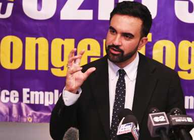 Man with beard and suit speaking Zohran Mamdani