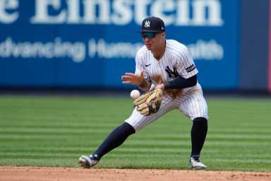 Anthony Volpe Yankees: Baseball player in white uniform fields groundball
