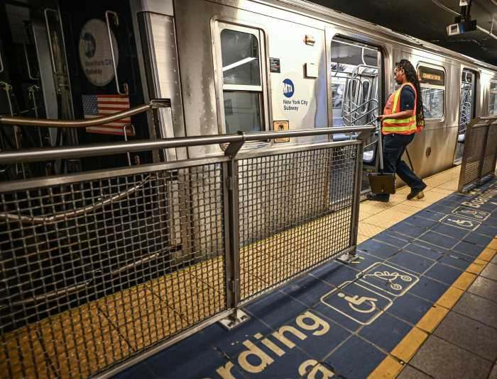 Subway safety upgrade: These 56 NYC stations now have platform barriers installed - with more on the way 2 a woman wearing a brightly colored vest enters a train