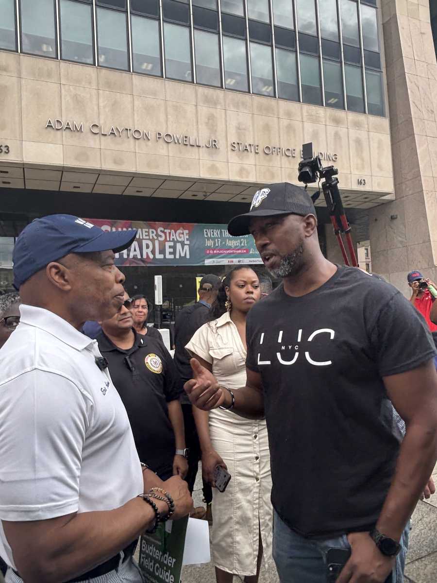 Budding idea: NYC ought to be the 'cannabis capital' of America, Mayor Adams says at Harlem fair 2 two men talking to each other in front of building about cannabis policies