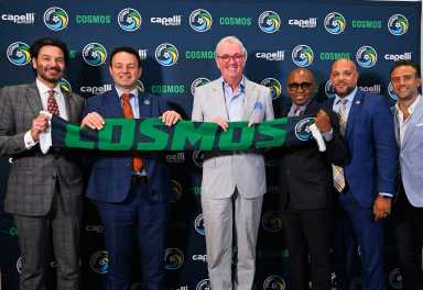 Cosmos: Men in suits pose with scarf in front of dark blue backdrop