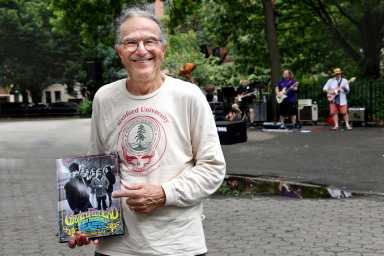 Man in The Grateful Dead shirt holding book with photograph