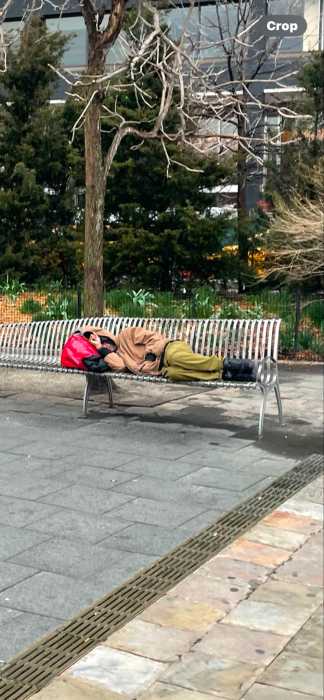 man sleeping on a bench outside