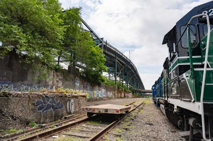 IBX: Transit boon or suburban bane? New rail line poised to boost property values but threaten neighborhood charm 4 railroad tracks and locomotive near trees on the IBX line