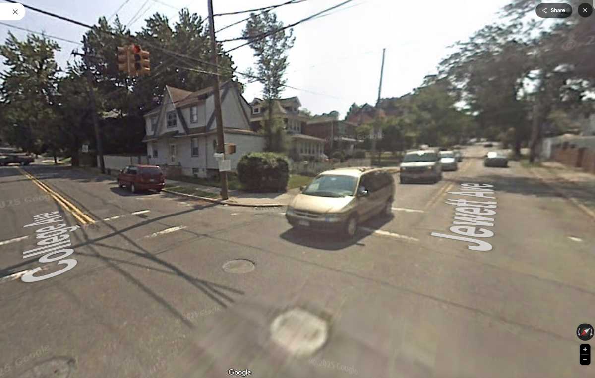 a street intersection lined with trees and houses