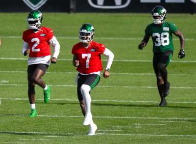 Jets get a training camp scare as QB Justin Fields dislocates toe 18 Jets quarterback in red and green gear warming up on practice field