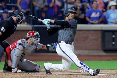 Juan Soto Mets: Baseball player in grey uniform follows through on single