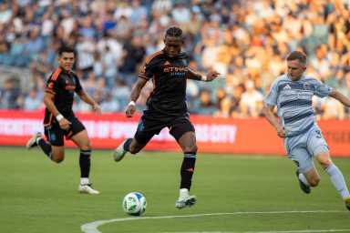 Player in black clothing kicks soccer ball on field for NYCFC