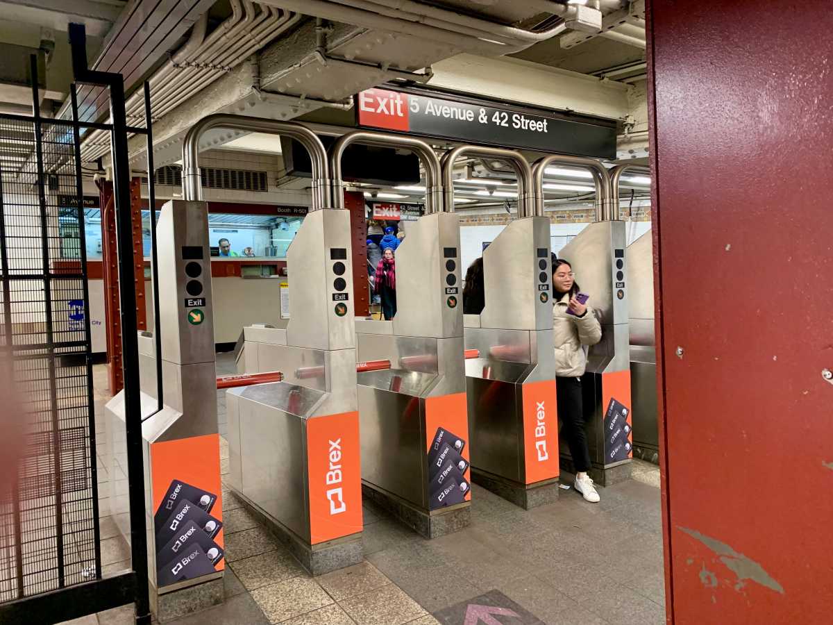 woman walking through NYC subway turnstile