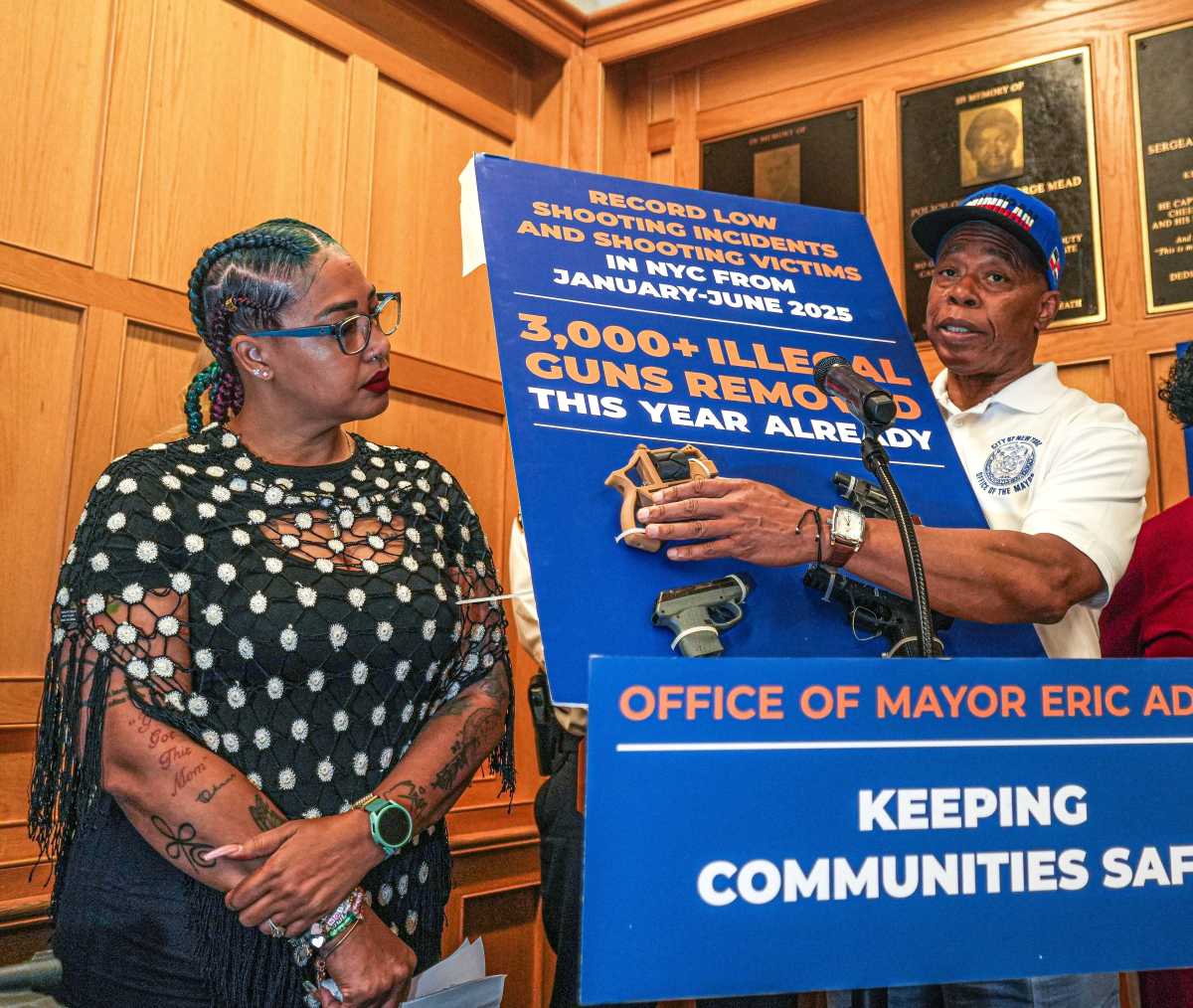 man with woman pointing out 3D printed guns on board