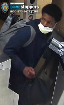 Man in white mask exiting subway turnstile after woman slashed