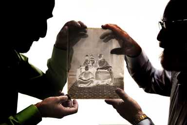 two men in Flatiron District holding up glass negative photography