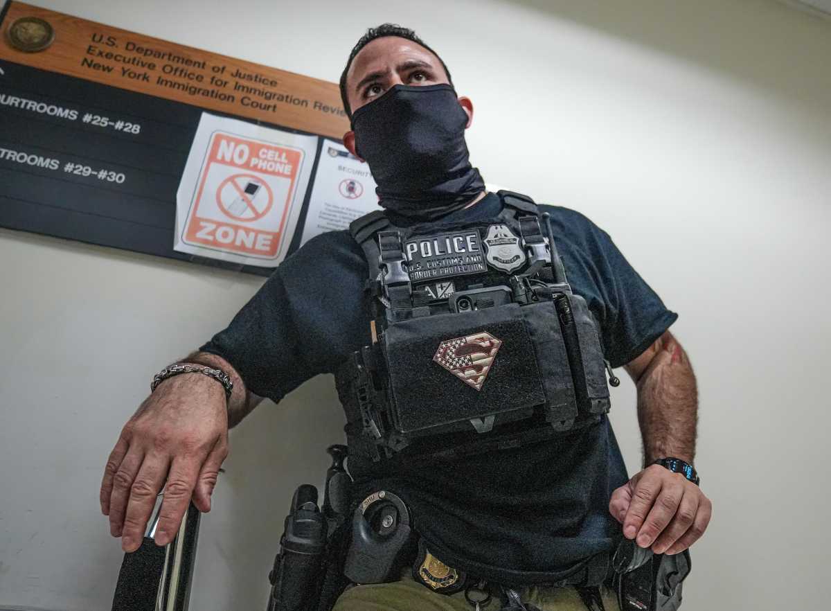 ICE agent in court with Superman patch on his vest