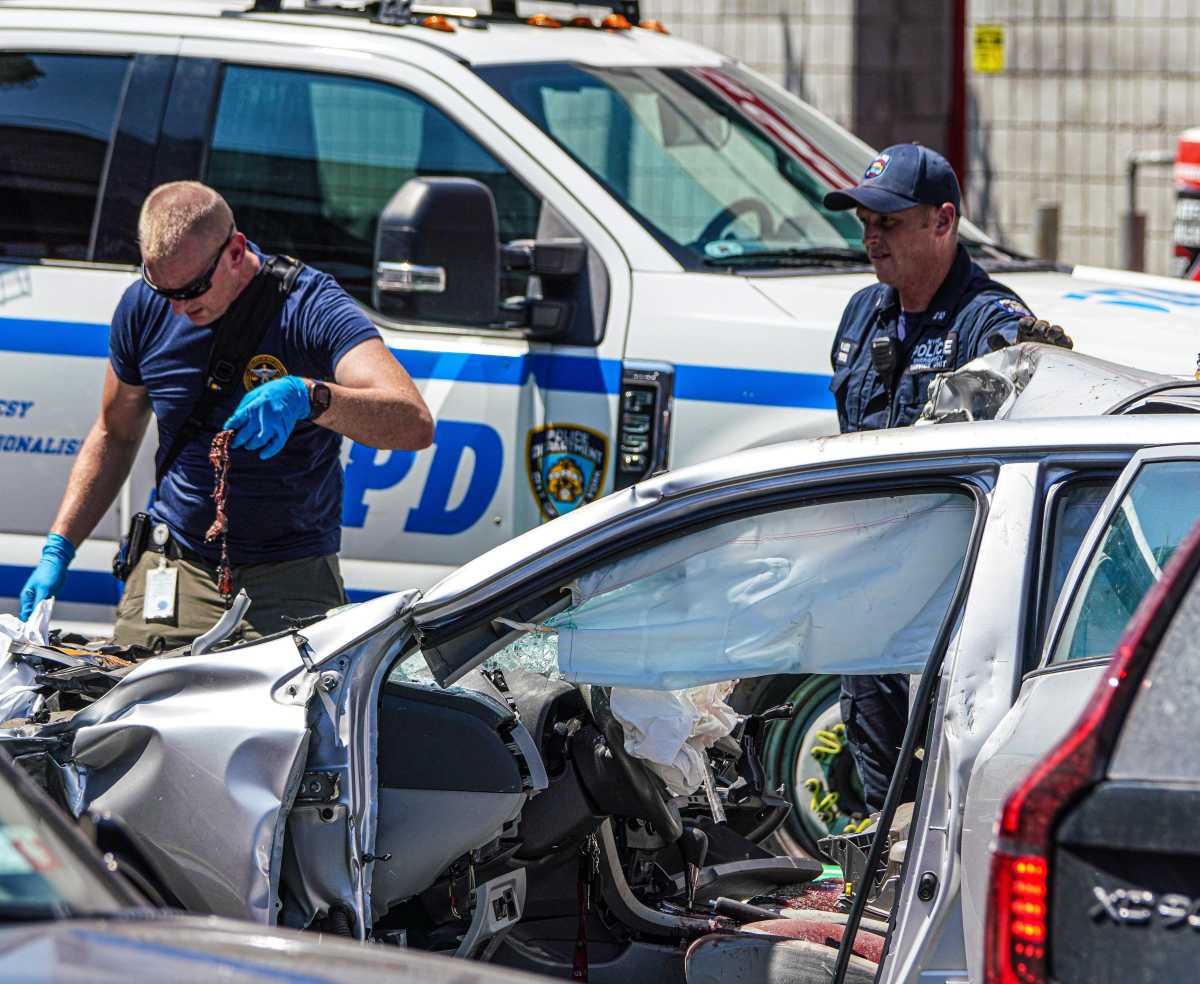 Carnage in Queens: Senior driver killed with two other men in crash near food cart had stroke weeks before wreck 2 police officer removes debris from smashed up vehicle in Queens car crash