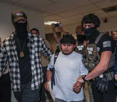 ICE agents with detained immigrant