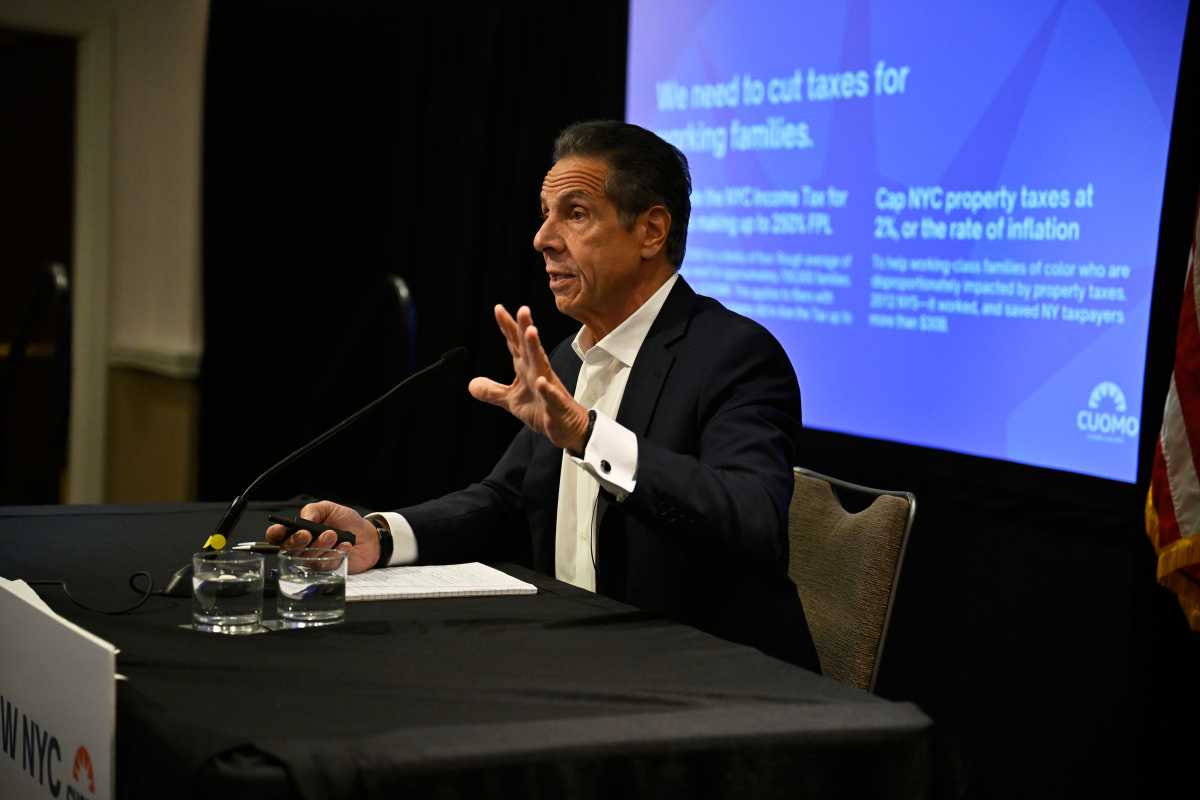 NYC Mayor's Race: Cuomo presents plan on affordability, painting Mamdani's pitch as irresponsible and unrealistic 1 Man in a suit presents in front of a big screen, sitting at a table with a microphone