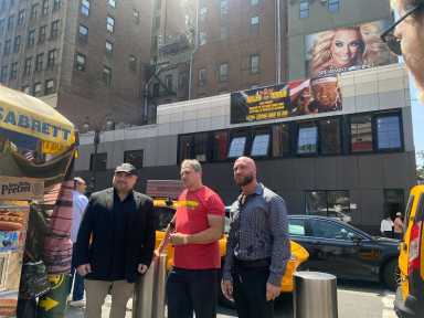 Nick Hogan and Rich Rosen stand outside the under-construction Slam Sports Bar in Midtown Monday, unveiling a tribute banner in honor of Hulk Hogan on what would have been the wrestling legend’s 72nd birthday.