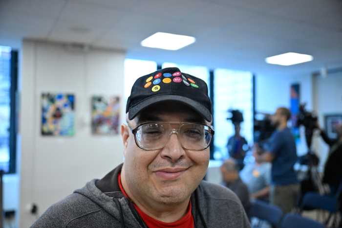man wearing a baseball hat with lots of letters on it