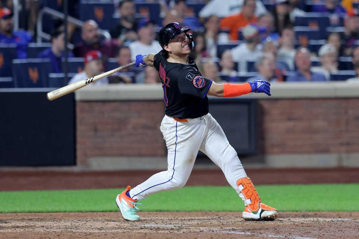 Francisco Alvarez injury Mets Mariners: Man in black uniform swings baseball bat