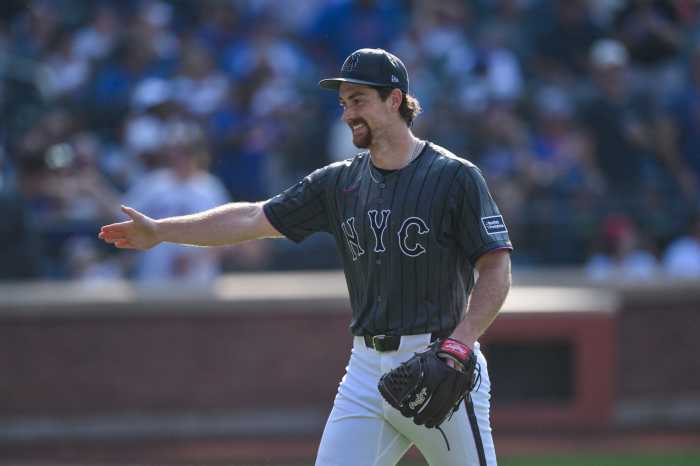 Mets player nolan mclean extends hand smiling after making double play