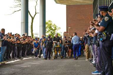 NYPD detective shot by 'friendly fire' while responding to Queens carjacking released from hospital as suspect is charged 22 officers applaud wounded cop as he leaves hospital after being hit with friendly fire